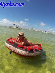 Big titted amateur lounges on an air mattress while naked in a ball cap